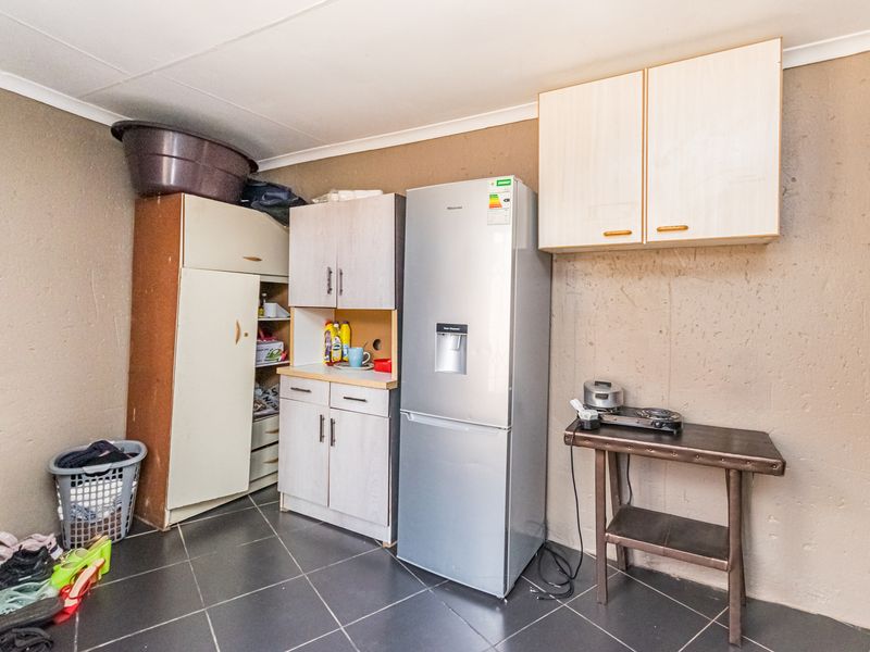 A functional kitchen area featuring tiled flooring and basic built-in cabinetry, providing essential storage and preparation space.
