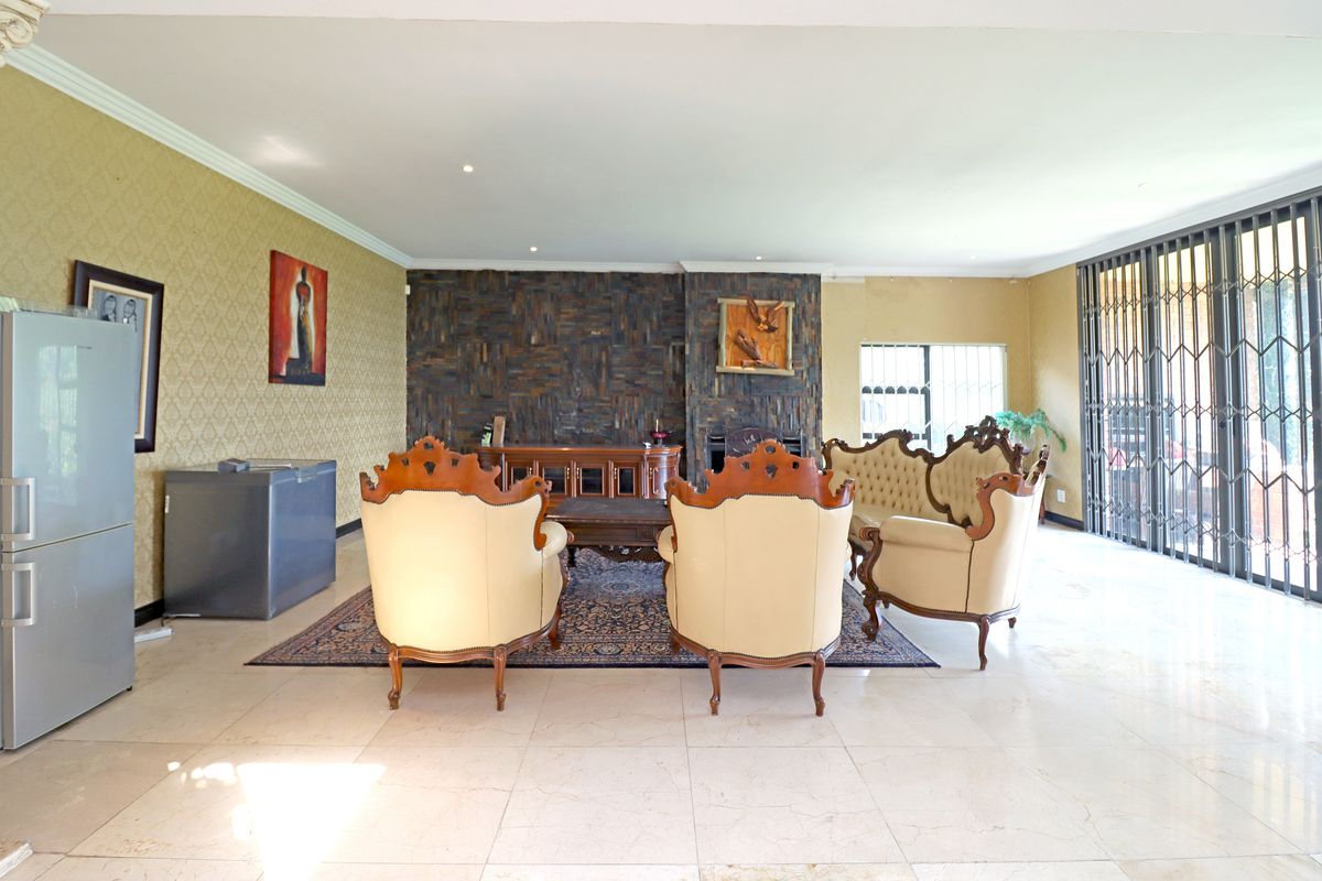 Spacious living area featuring tiled flooring, a textured feature wall with a fireplace, and large sliding doors leading to the exterior.