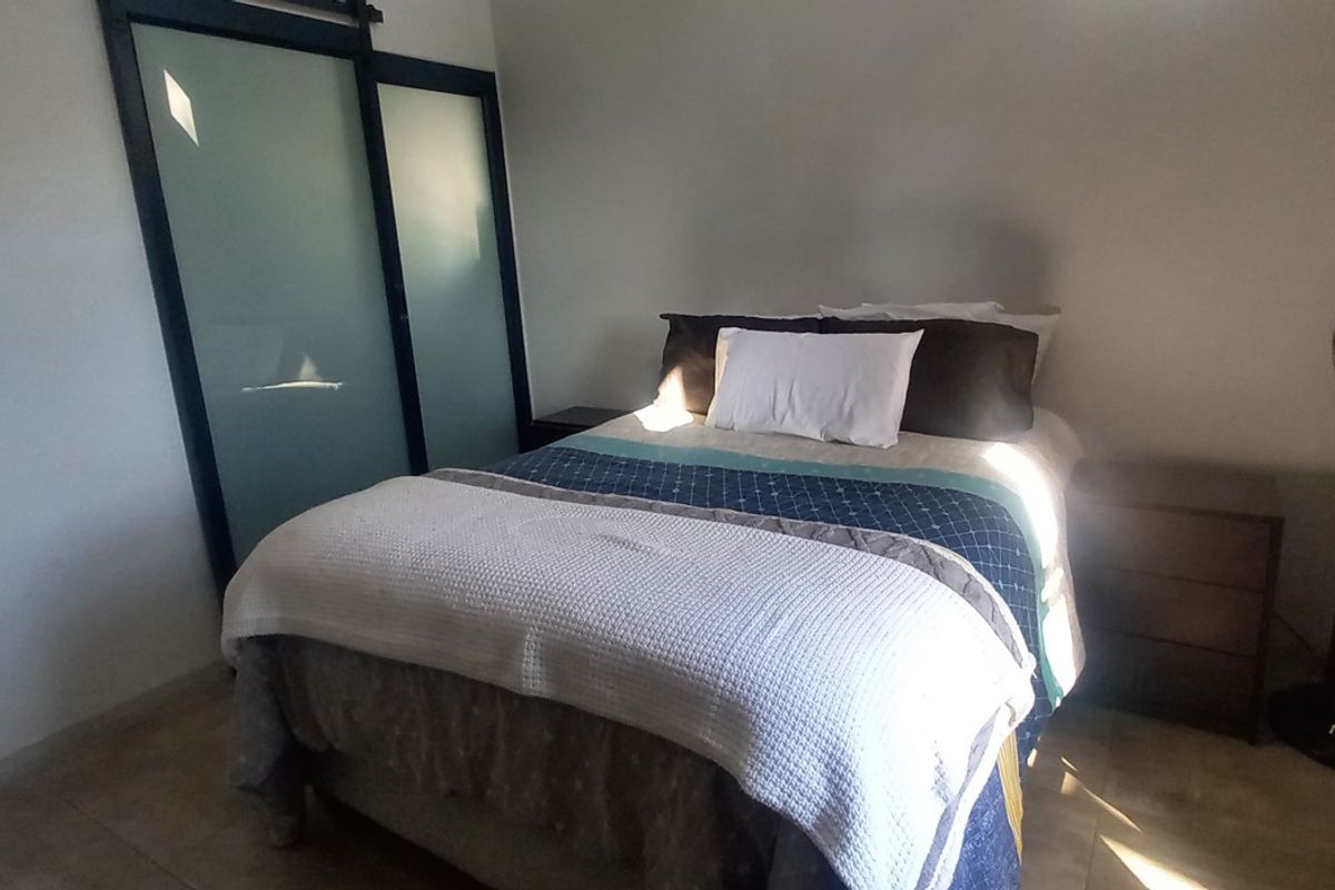 A bedroom featuring tiled flooring and a built-in sliding door closet with frosted glass panels.
