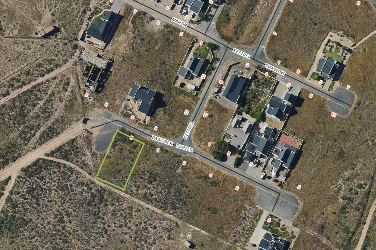 Aerial view of a vacant residential plot located in a developed estate, highlighting its position relative to existing street infrastructure and neighboring properties.