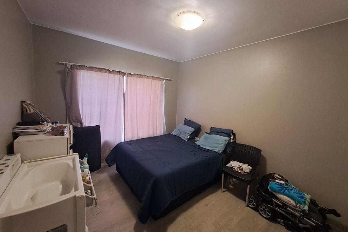 A standard bedroom featuring laminate flooring and neutral wall tones, providing a functional space ready for personalization.
