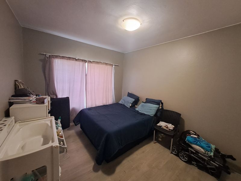 A standard bedroom featuring laminate flooring and neutral wall tones, providing a functional space ready for personalization.