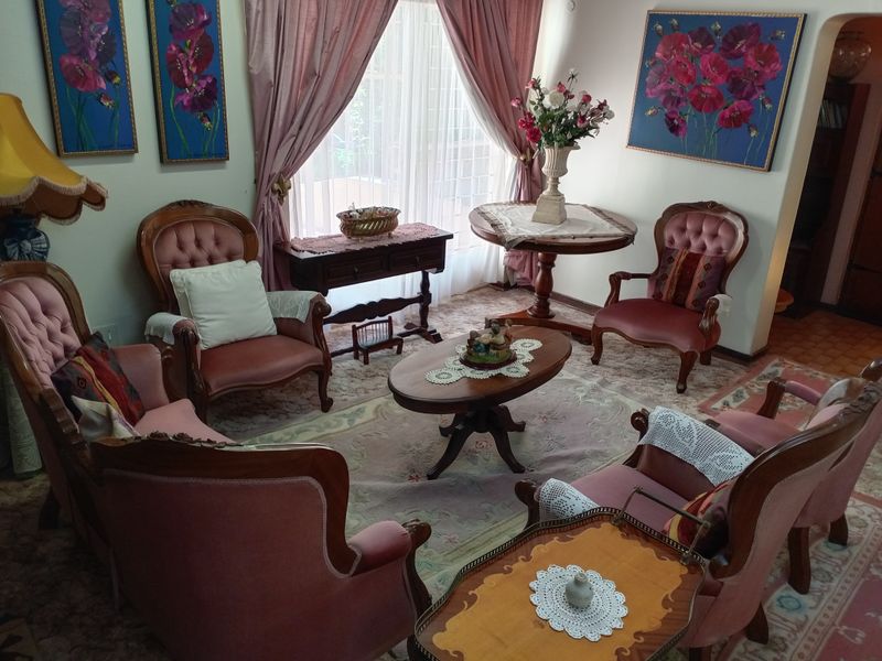 A traditional living room space featuring large windows with curtains, providing a classic layout suitable for modern updates.