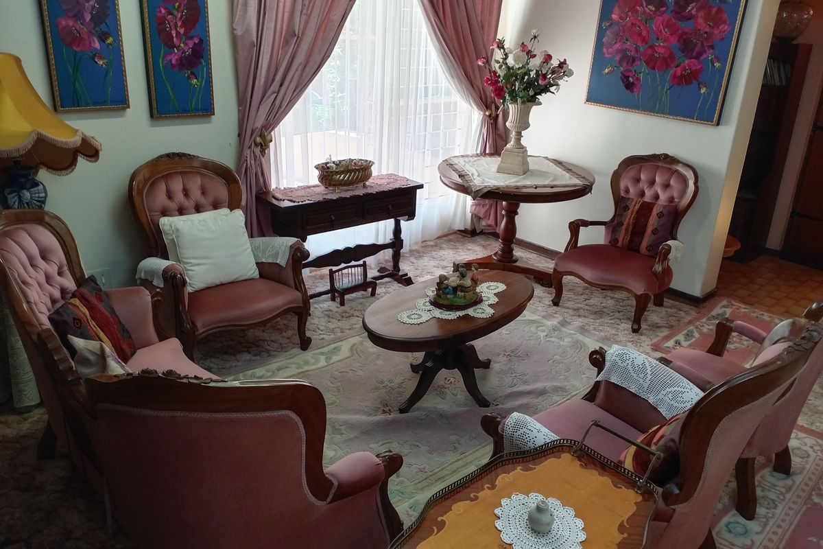 A traditional living room space featuring large windows with curtains, providing a classic layout suitable for modern updates.