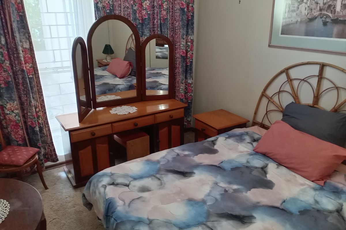 A bedroom featuring a sliding glass door providing natural light and access to the exterior.