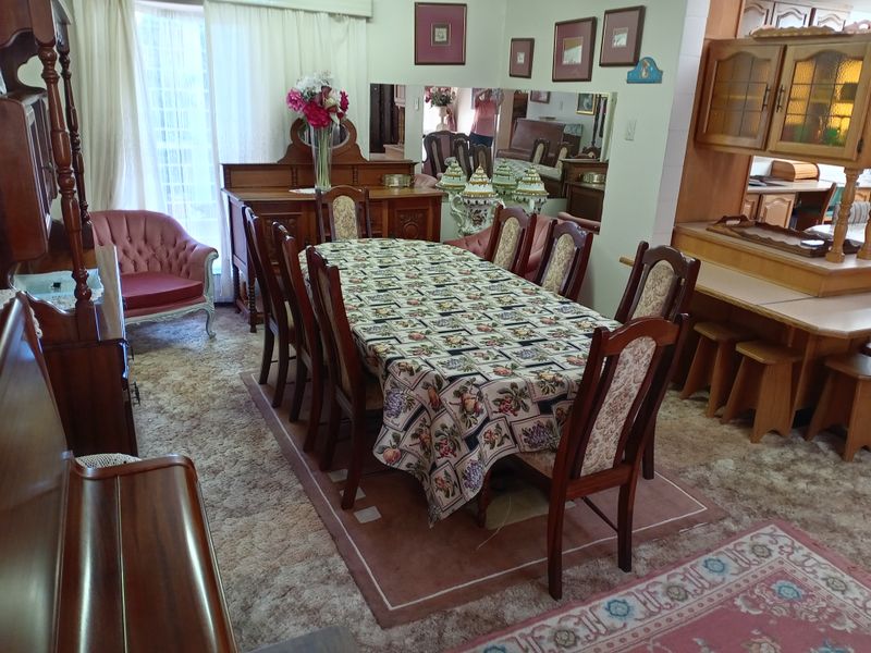 A traditional dining room featuring a large dining table area with adjacent built-in cabinetry and a breakfast bar counter.