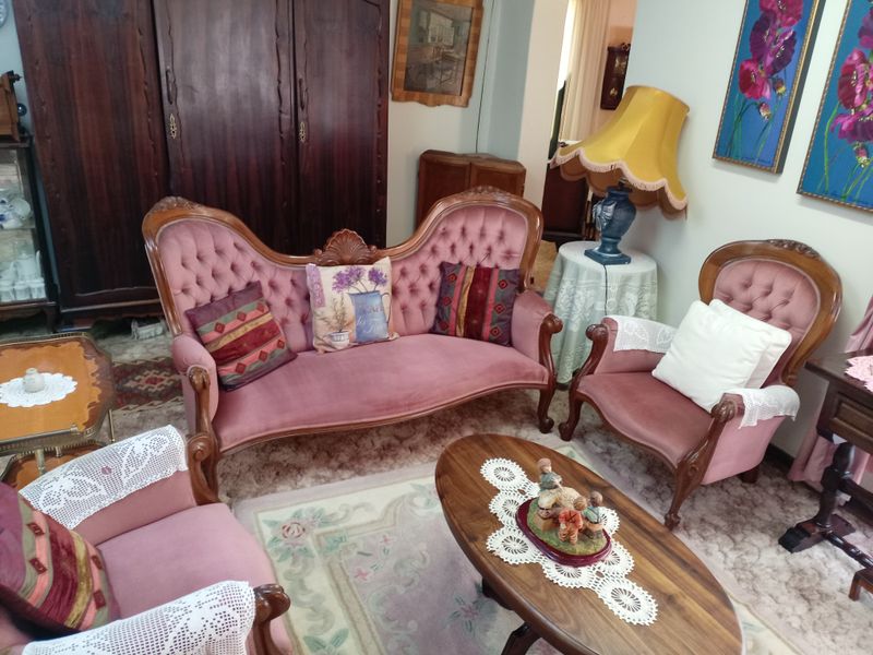 A traditional living room space featuring carpeted flooring and neutral wall finishes, suitable for modernization.