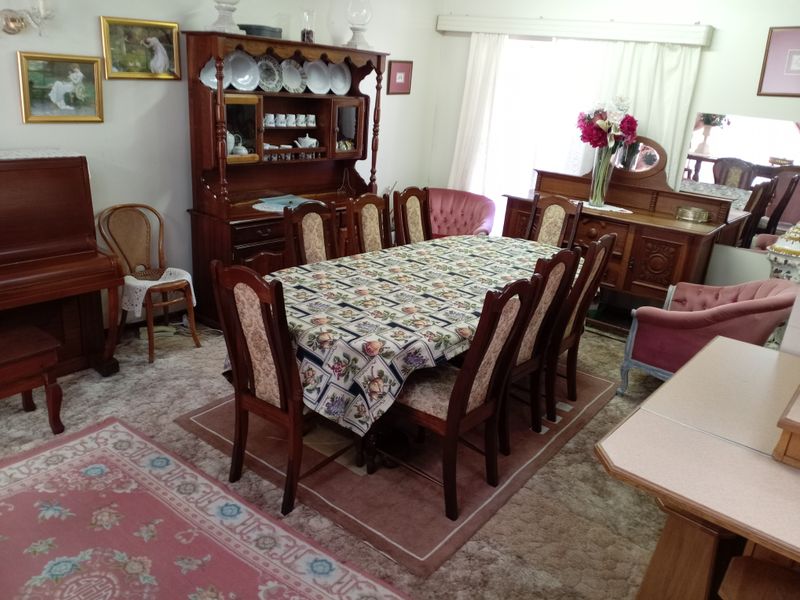 A traditional dining room featuring carpeted flooring and window treatments, offering a classic layout suitable for modernization.