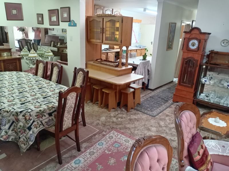 Open plan dining and living area featuring dated cabinetry and carpet flooring, offering potential for modernization and updated interior finishes.