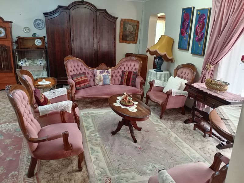 A traditional living room featuring an arched doorway and classic architectural layout, offering a spacious area for relaxation and formal seating.