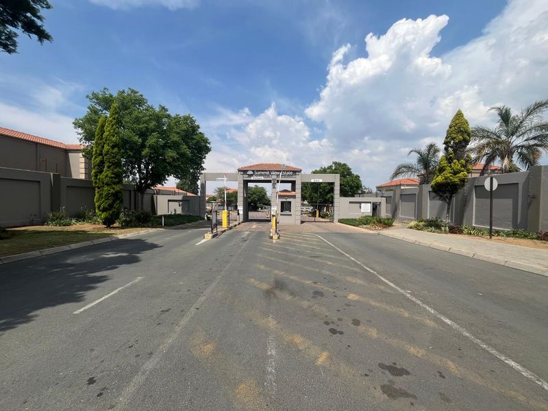 The main entrance gatehouse and security access point for Summit View Estate, featuring boom gates and perimeter walling.