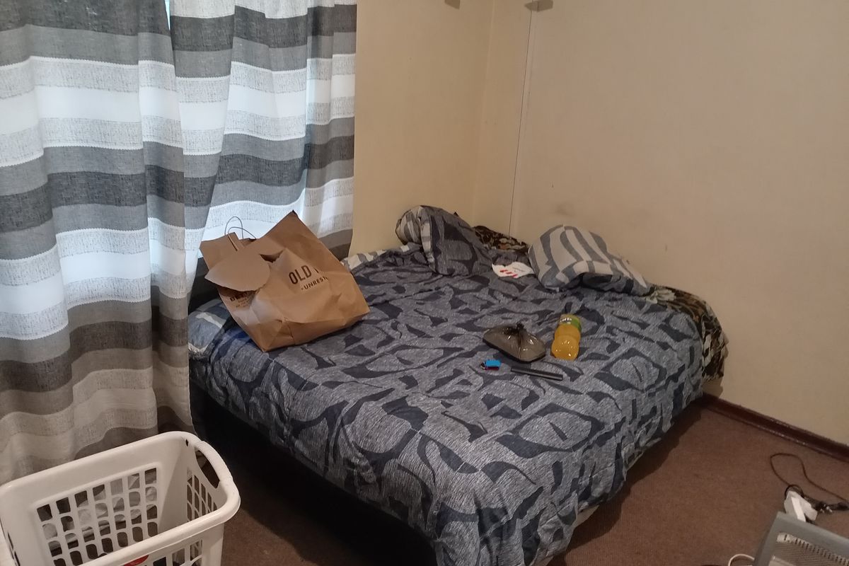 A bedroom featuring carpeted flooring and a window with curtains.