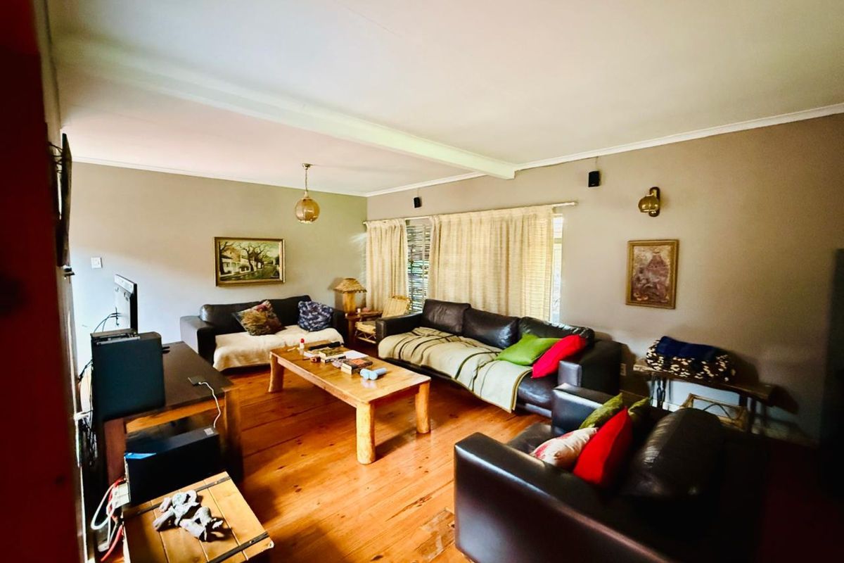 Spacious living room featuring polished timber flooring, neutral wall tones, and natural light through window treatments.