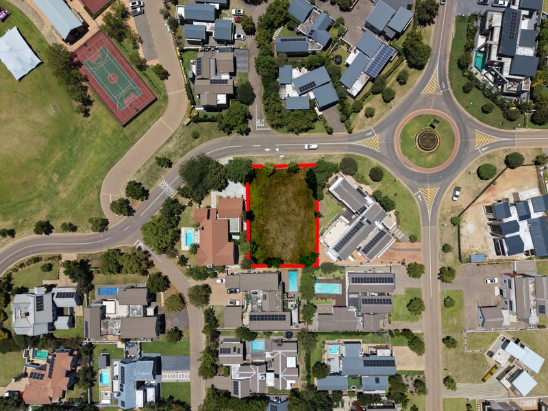 Aerial view of a vacant residential land plot situated within a developed estate, highlighting the property boundaries and surrounding neighborhood infrastructure.