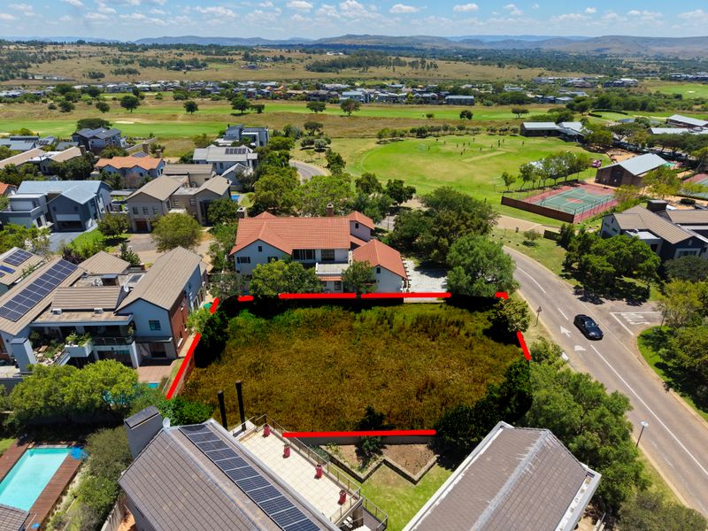 Aerial view of a vacant residential plot situated within a developed estate, highlighting the property boundaries and surrounding neighborhood infrastructure.
