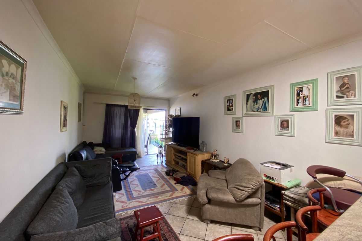A functional living room featuring tiled flooring and direct access to an outdoor area through a sliding door.