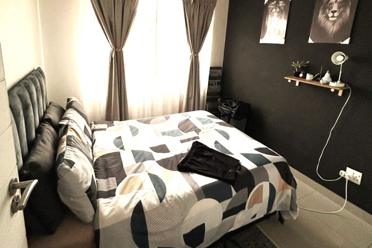 A cozy bedroom featuring tiled flooring, neutral wall finishes, and a dark accent wall, providing a comfortable and modern sleeping space.