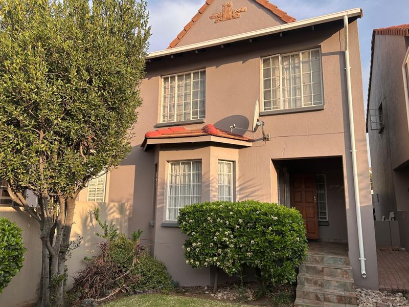 Front elevation of a double-story townhouse featuring a tiled roof, bay window, and stone-tiled entrance steps.