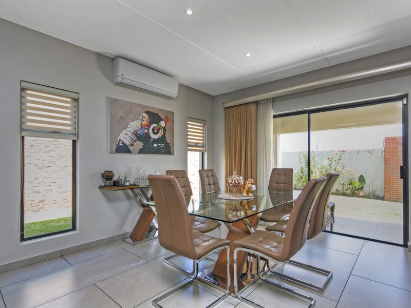 Bright dining area featuring tiled flooring, recessed lighting, split-system air conditioning, and large sliding glass doors providing direct access to the patio.