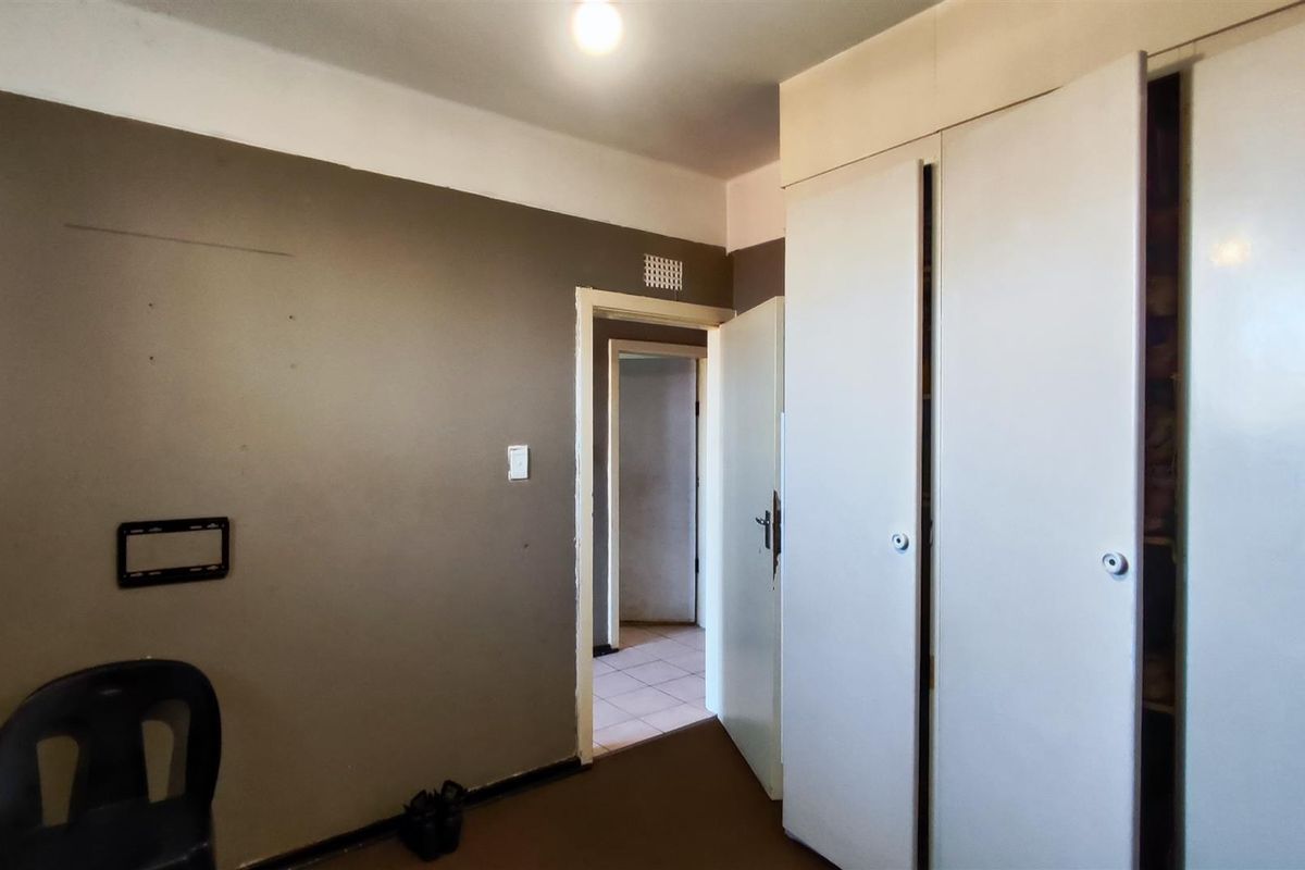 A bedroom featuring built-in cupboards and a neutral wall finish, offering a blank canvas for potential renovation or interior design updates.