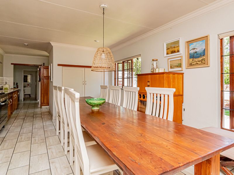 Open-plan kitchen and dining area featuring tiled flooring, built-in cabinetry, a gas hob with extractor, and direct access to the outdoor patio.