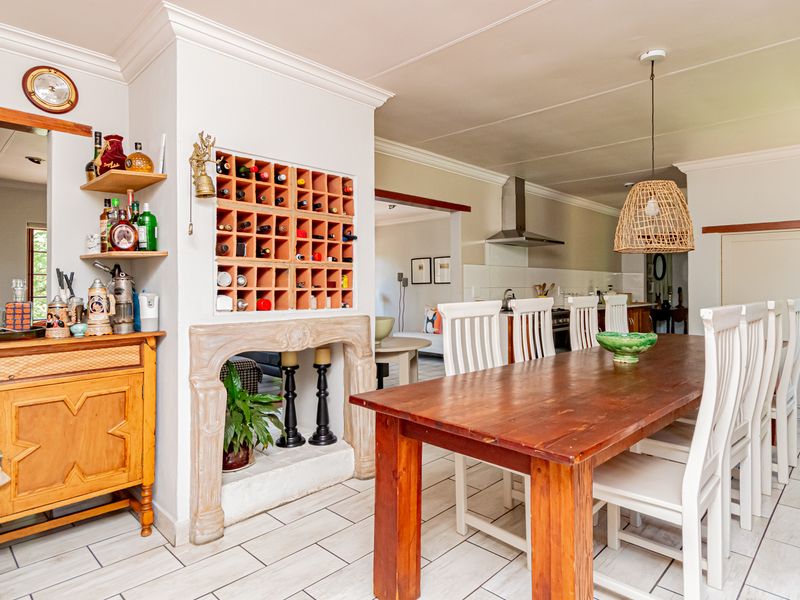 Open-plan dining area featuring tiled flooring, a decorative stone fireplace surround with integrated wine storage, and a seamless flow into the kitchen space.