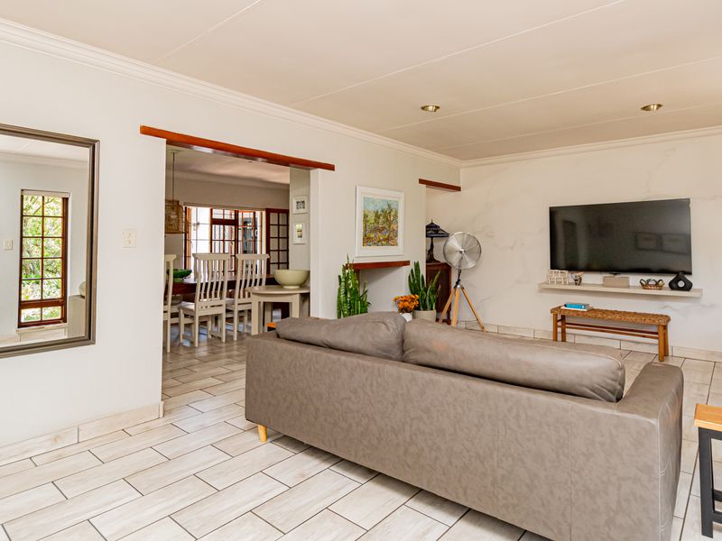 Spacious open-plan living area featuring tiled flooring, recessed lighting, and a seamless transition to the adjacent dining space.