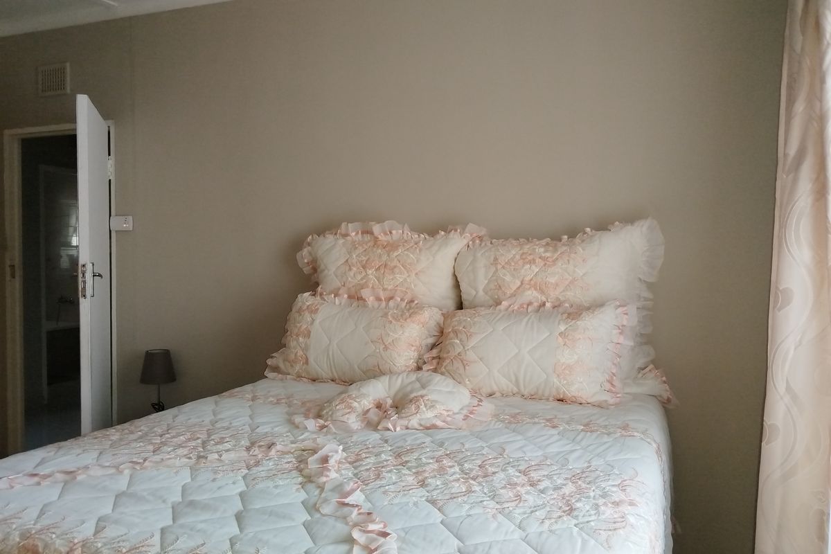 A bedroom featuring neutral wall tones and a doorway leading to an adjacent space.