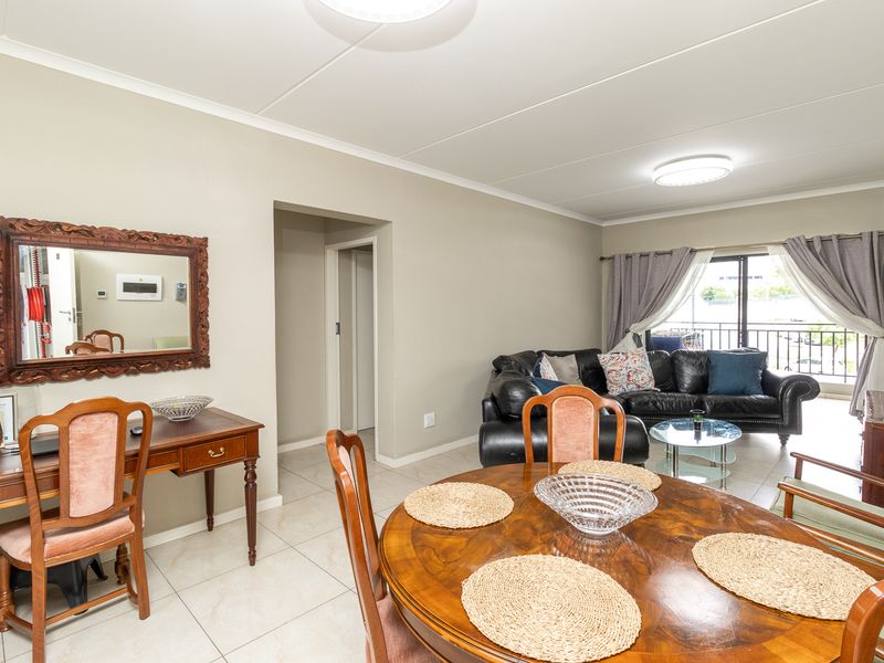 Open plan living and dining area featuring tiled flooring and a sliding glass door leading to a balcony.
