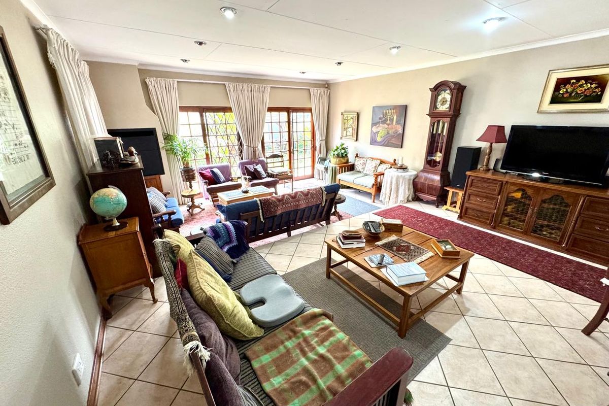 Spacious living room featuring tiled flooring, recessed lighting, and large glass sliding doors providing access to the outdoor area.