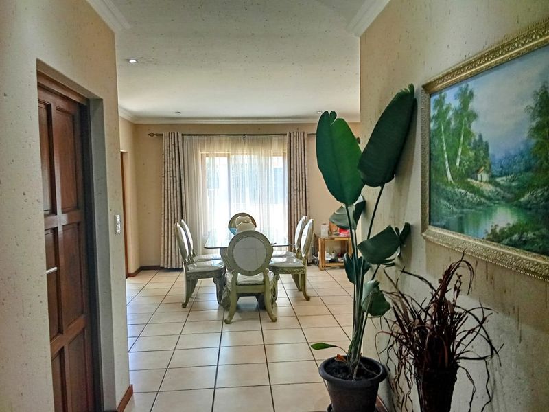 A dining area featuring tiled flooring, recessed lighting, and access to a patio through sliding glass doors, offering a functional space for family meals.