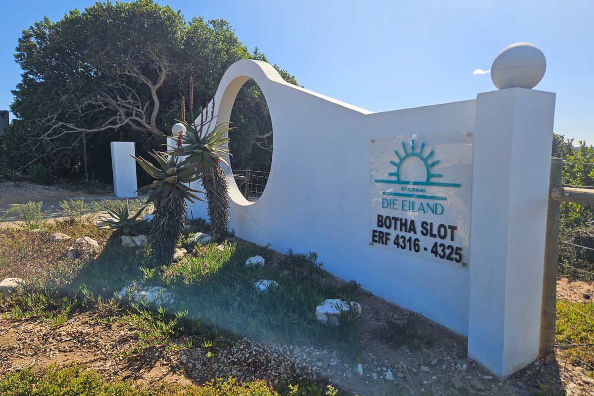 A well-maintained entrance wall and signage for the Die Eiland estate, featuring a modern architectural design and landscaped garden area.