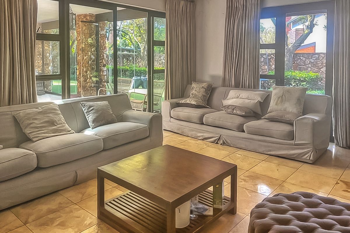 Spacious living room featuring large glass sliding doors that provide natural light and direct access to the outdoor patio area.