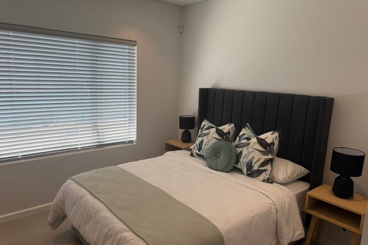 A well-maintained bedroom featuring neutral wall finishes, recessed ceiling lighting, and horizontal window blinds.