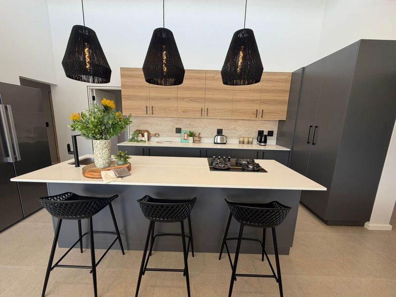 Modern kitchen featuring a central island with a built-in gas hob, sleek cabinetry, and high-quality stone countertops.