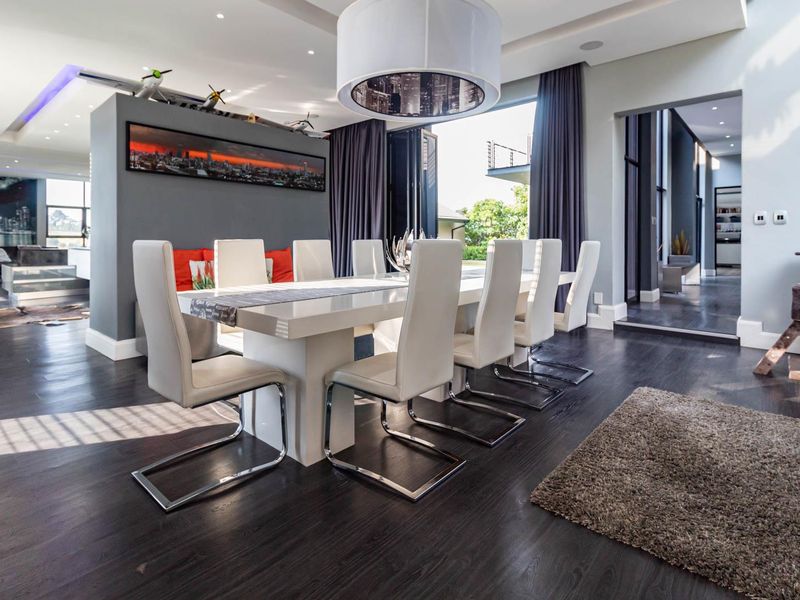 Spacious dining area featuring dark hardwood flooring, modern bulkhead ceiling with recessed lighting, and large bi-fold doors opening to the exterior.