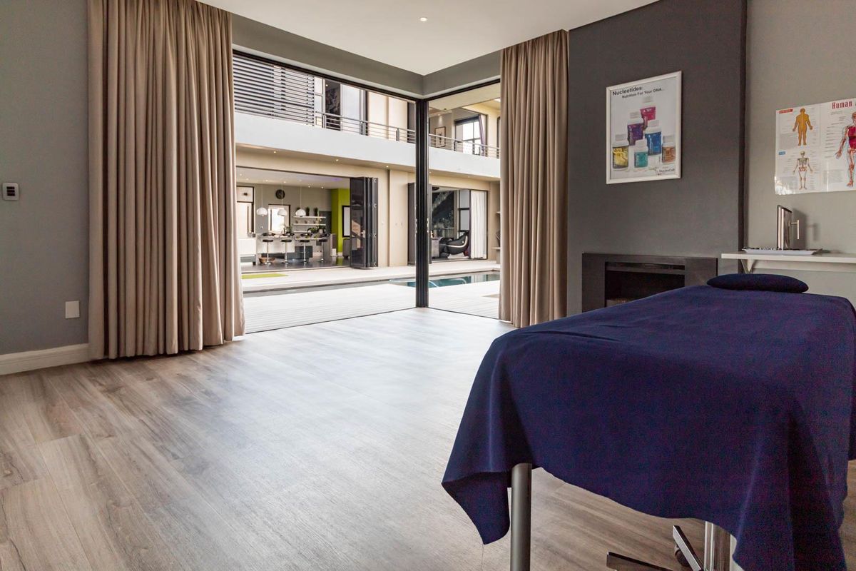 Spacious living area featuring large sliding glass doors that open onto a central courtyard with a pool, finished with modern laminate flooring.