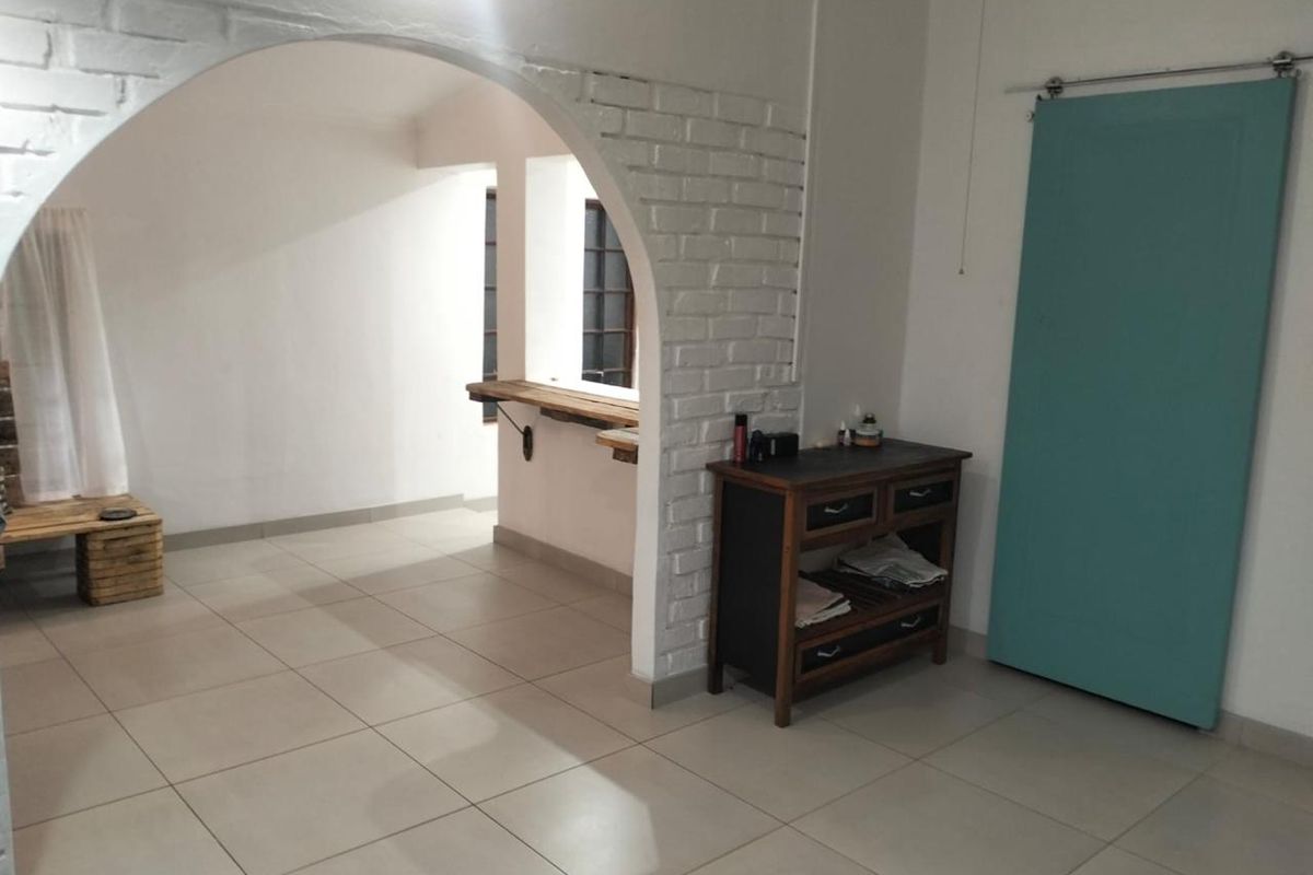 Interior view featuring a white painted brick archway, tiled flooring, and a sliding barn-style door leading to an adjacent space.