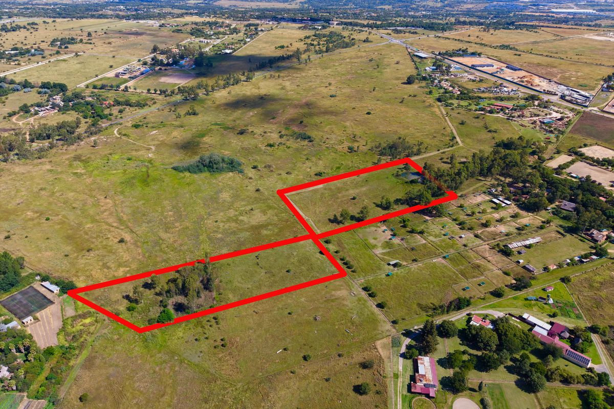 An aerial view of a large, undeveloped residential land parcel with clear boundary markings, situated in a semi-rural landscape.