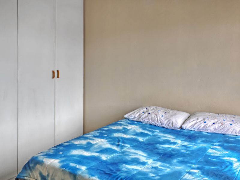 A bedroom featuring a white built-in wardrobe with simple hardware.