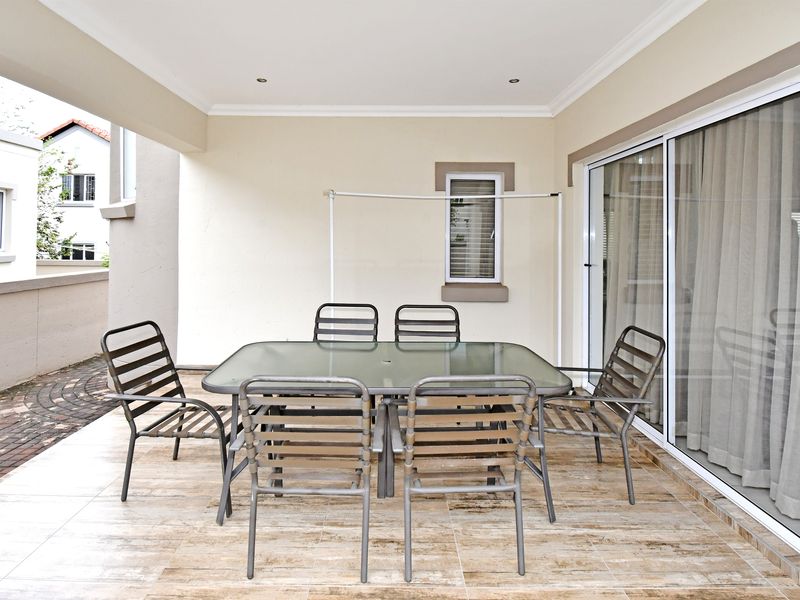 A covered patio area featuring tiled flooring, recessed lighting, and large sliding glass doors providing seamless access to the interior living space.