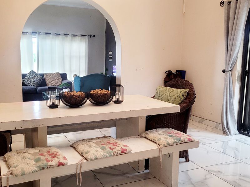 Dining area featuring tiled flooring, an arched entryway leading to the living space, and bi-fold doors providing access to the exterior.