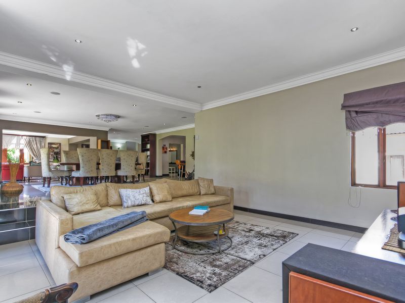 Spacious open-plan living and dining area featuring tiled floors, recessed lighting, and neutral wall finishes, creating a bright and versatile living space.