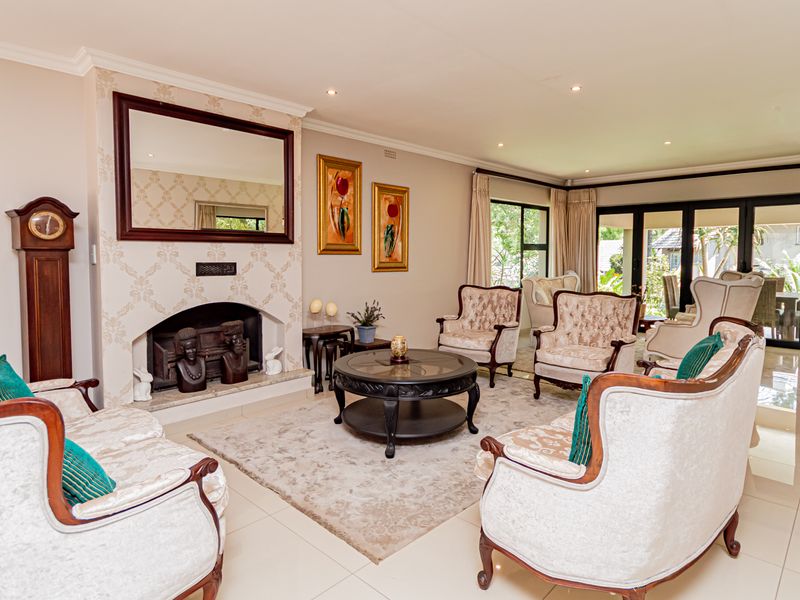 Spacious living room featuring a classic fireplace, tiled flooring, and large sliding glass doors that provide ample natural light and access to the patio.