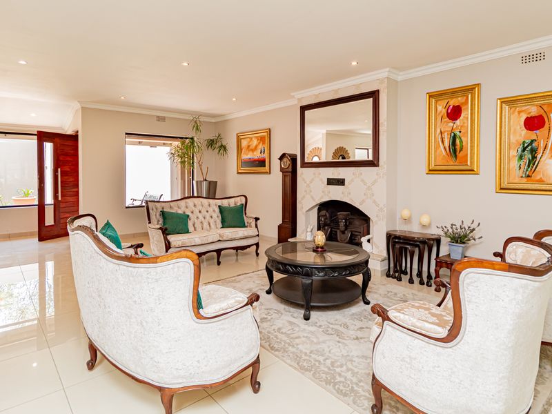 A well-maintained living room featuring tiled flooring, recessed downlights, and a central fireplace, creating a bright and inviting space.