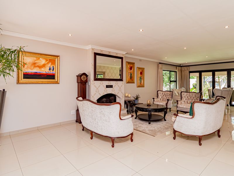 Spacious living room featuring tiled flooring, recessed downlights, a central fireplace, and large sliding glass doors providing access to the outdoor area.