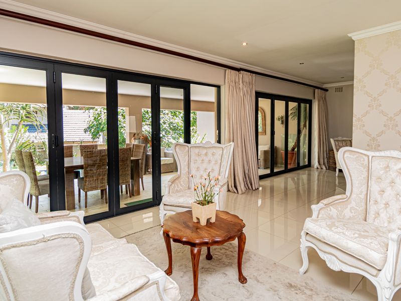 Spacious living area featuring large black-framed bi-fold doors that provide seamless access to the outdoor patio and garden area.