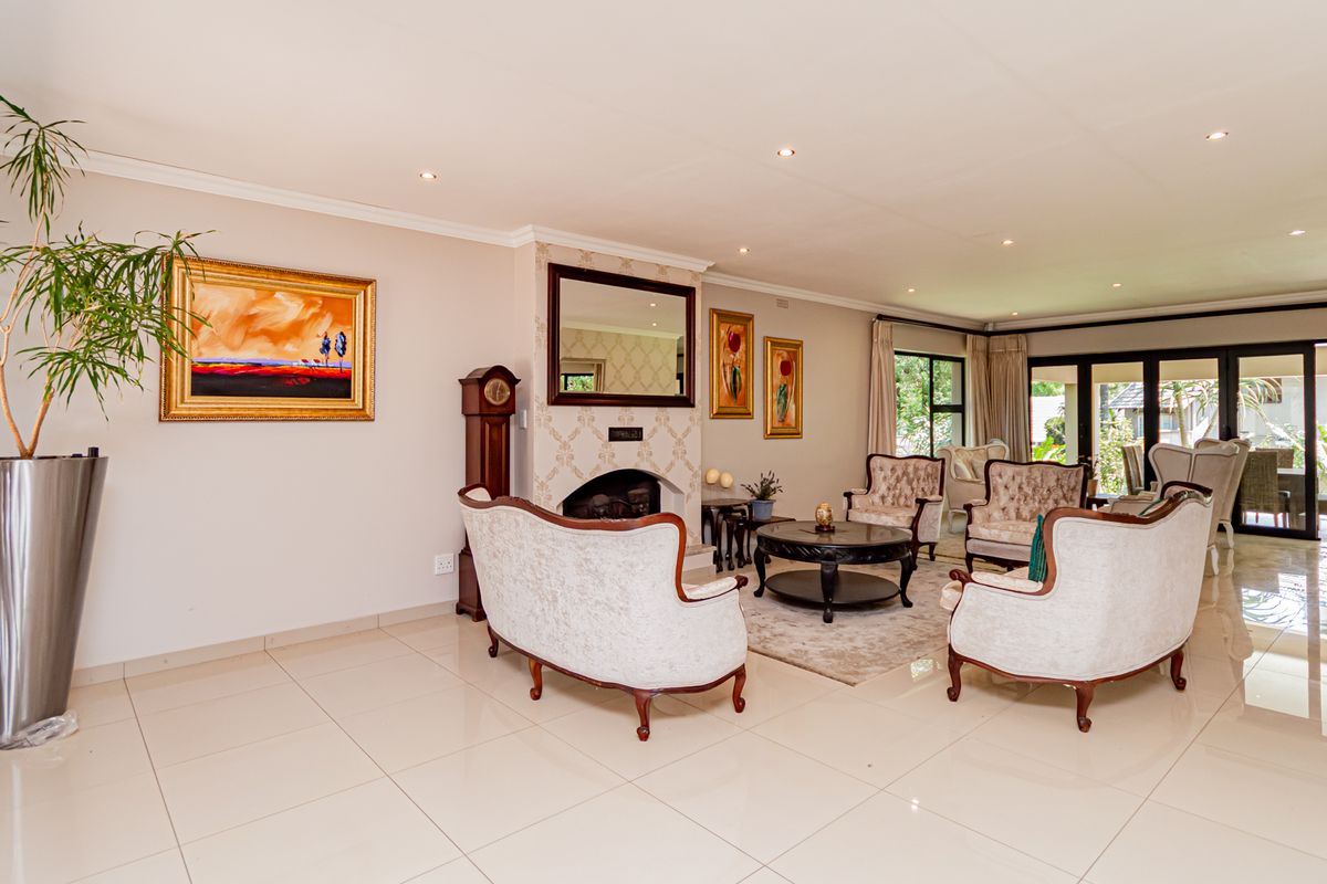 Spacious living room featuring tiled flooring, recessed downlights, a central fireplace, and large sliding glass doors providing access to the outdoor area.