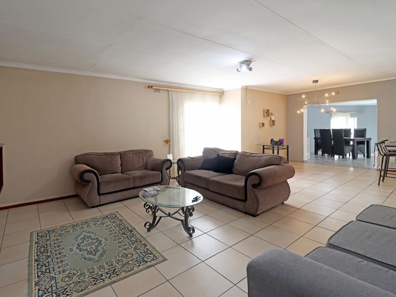 Spacious open-plan living and dining area featuring neutral tiled flooring and direct access to outdoor space through a sliding glass door.