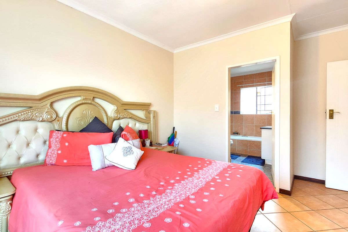 A bedroom featuring tiled flooring and cove cornicing, with direct access to an en-suite bathroom.